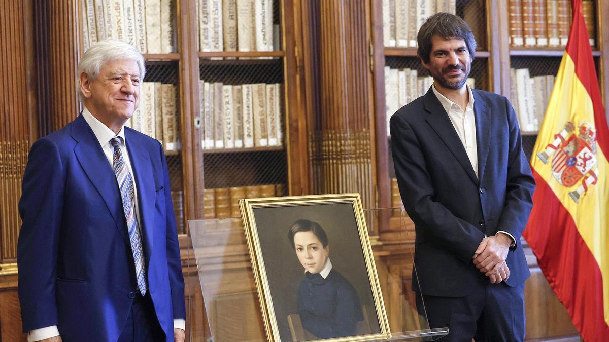 El presidente de la Fundación Francisco Giner de los Ríos, José García-Velasco, y el ministro de Cultura, Ernest Urtasun, posan junto al lienzo restituido.