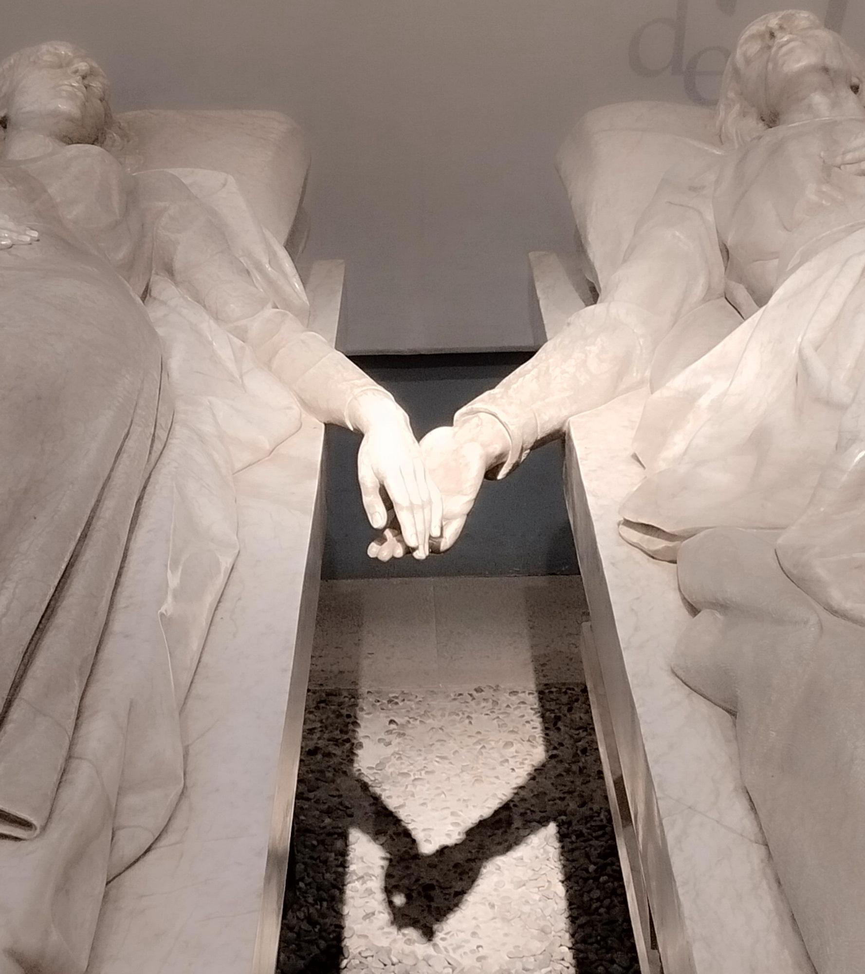 Detalle de las manos que no llegan a tocarse.