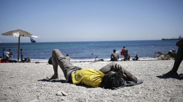Un joven migrante descansa en una playa de Ceuta.