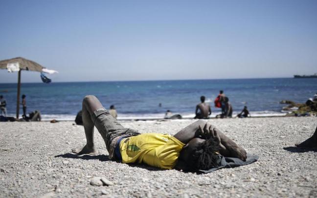 Un joven migrante descansa en una playa de Ceuta.