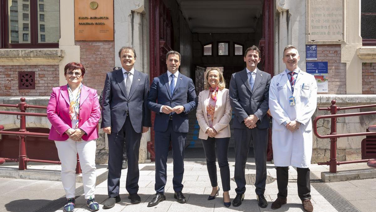 El lehendakari, Imanol Pradales, y la presidenta del BEI, Nadia Calviño -en el centro-, en la entrada del Hospital del Basurto.