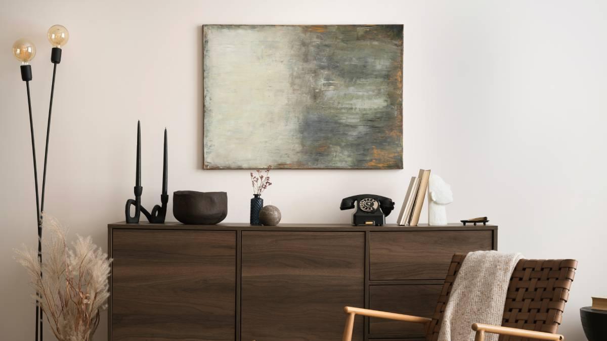 Cómoda de madera oscura como protagonista de un rincón muy estilo en el hogar.