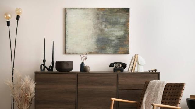 Cómoda de madera oscura como protagonista de un rincón muy estilo en el hogar.