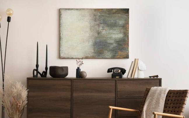 Cómoda de madera oscura como protagonista de un rincón muy estilo en el hogar.