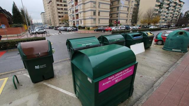 En primer plano, un contenedor destinado a ropa y calzado usados.