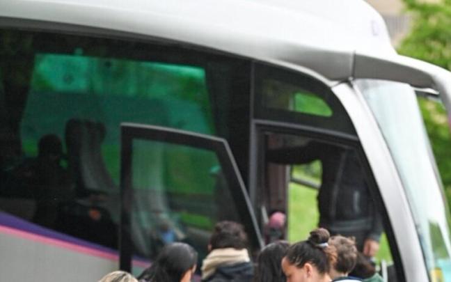 Niños y niñas esperan para subir al transporte escolar