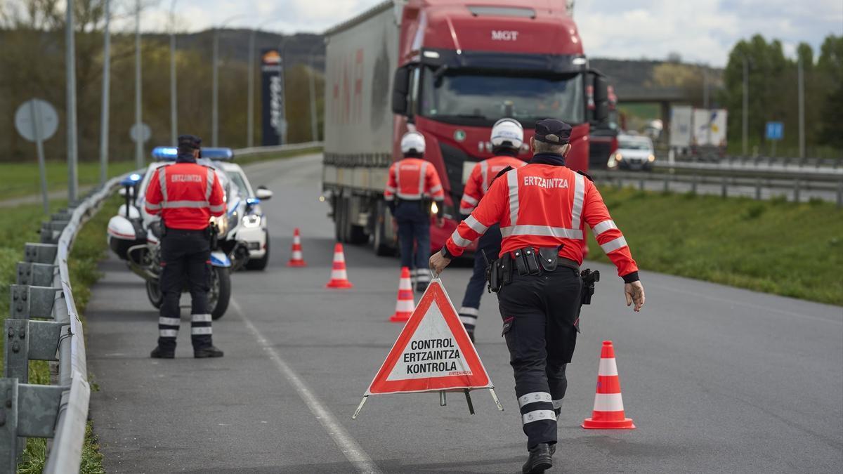 Agentes de la Ertzaintza establecen un control de camiones en la carretera.