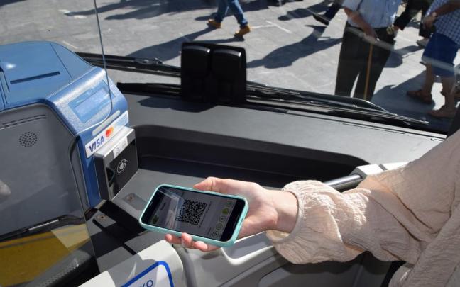Una persona muestra el código QR en la máquina validadora del autobús. Una persona muestra el código QR en la máquina validadora del autobús.