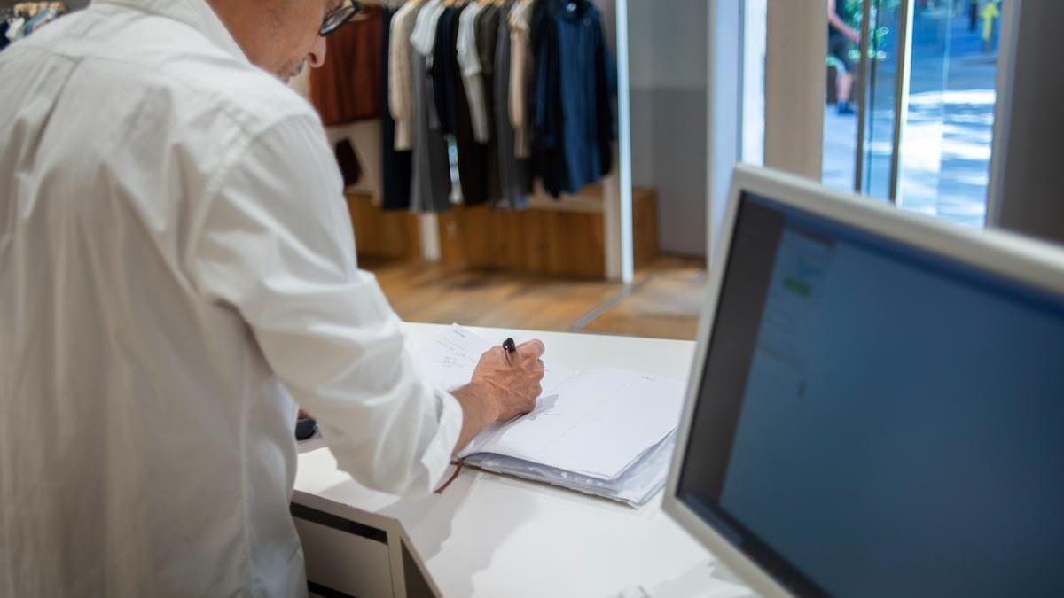 Encargado de una tienda revisando las transacciones diarias