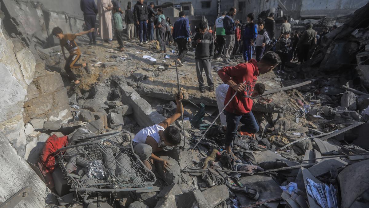 Un grupo de personas buscan entre los escombros de un edificio destruido en Gaza.