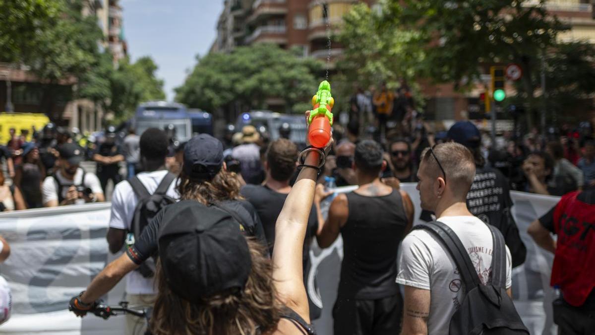 Varias personas con pistolas de agua durante una manifestación contra la masificación turística en Barcelona.