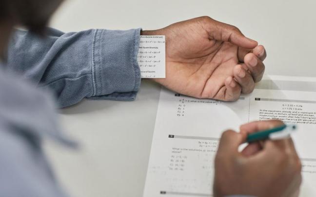 Un estudiante saca de la manga una chuleta. Un estudiante saca de la manga una chuleta.