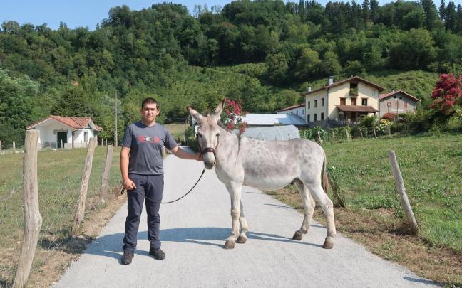 Mikel Lizarazu, con su burro, en el bidegorri, delante del caserío Izukitza.