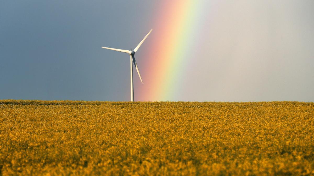 Un arcoiris brilla cerca de un molino de viento después de una tormenta.