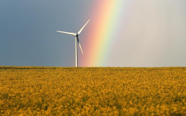 Un arcoiris brilla cerca de un molino de viento después de una tormenta. Un arcoiris brilla cerca de un molino de viento después de una tormenta.
