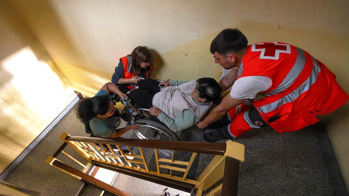 Efectivos de emergencias ayudan a una mujer a subir las escaleras durante el apagón.