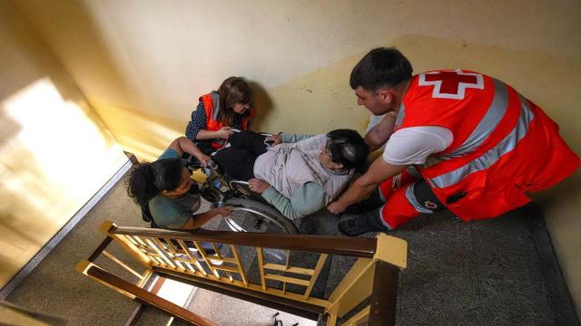 Efectivos de emergencias ayudan a una mujer a subir las escaleras durante el apagón.