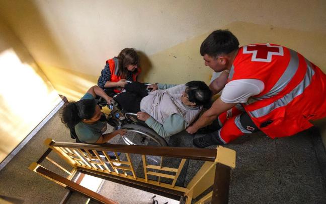 Efectivos de emergencias ayudan a una mujer a subir las escaleras durante el apagón.