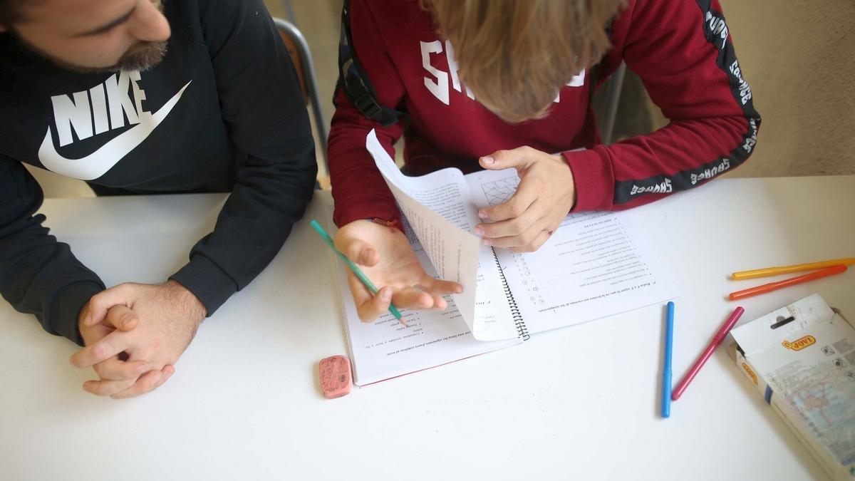 Un profesor ayuda a un estudiante con las tareas escolares en un colegio de Ortuella.