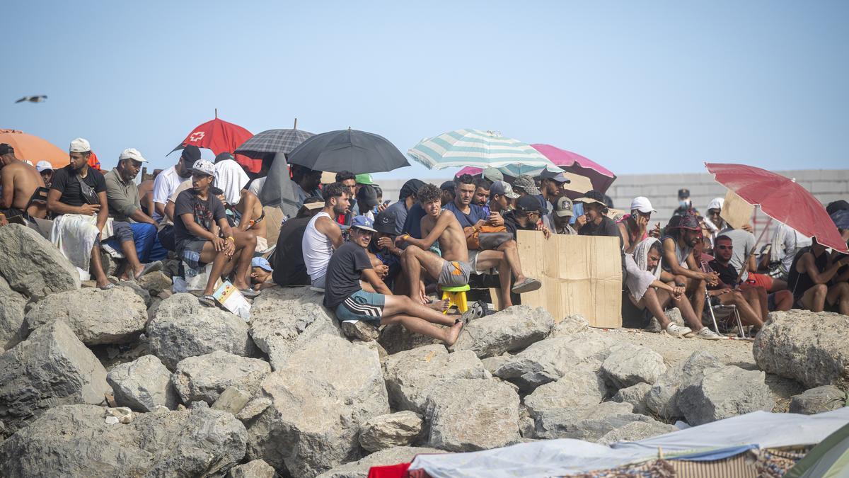 Varios migrantes acampados en la playa del Trampolín.