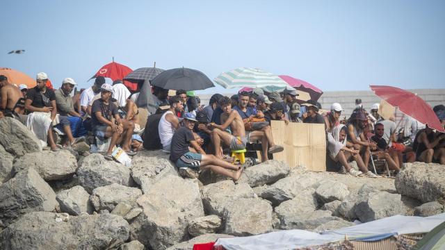 Varios migrantes acampados en la playa del Trampolín.