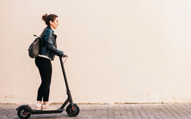 Una mujer circula con un patinete eléctrico.