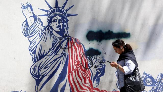 Una mujere iraní camina junto a un mural antiestadounidense cerca de la antigua Embajada de Estados Unidos en Teherán.