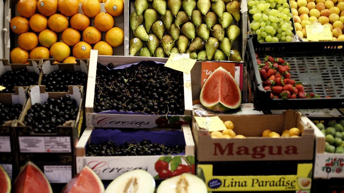 Naranjas, peras, limones, uvas, sandías, melones, fresas y cerezas en un mercado.