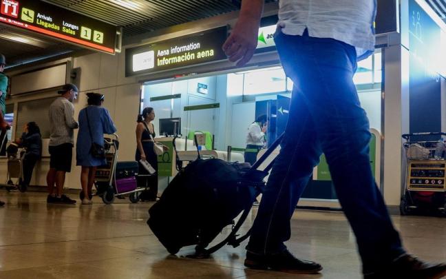 Un hombre transporta su maleta en un aeropuerto