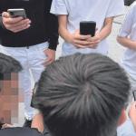 Un grupo de menores, ajenos a esta información, consultan sus teléfonos móviles reunidos en una calle de Bilbao.