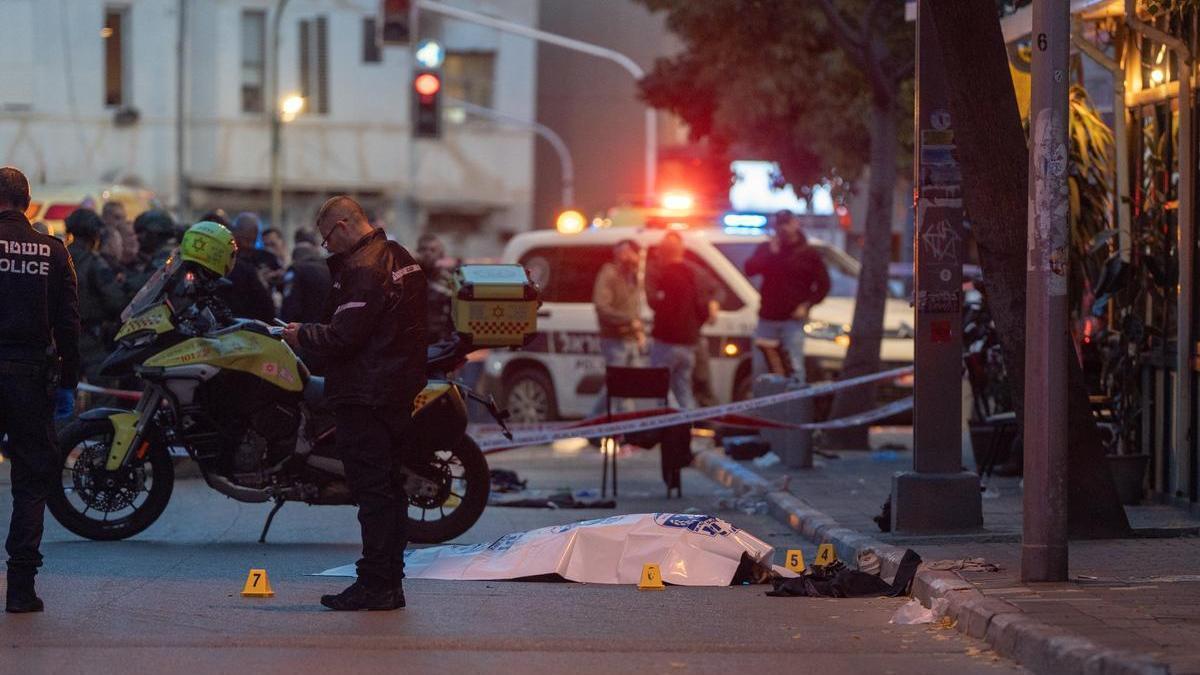 Agentes de la policía israelí junto al cadáver del palestino abatido en Tel Aviv.