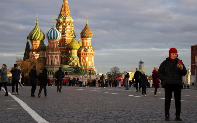 Personas paseando por la plaza Roja de Moscú, con la Catedral de San Basilio de fondo.