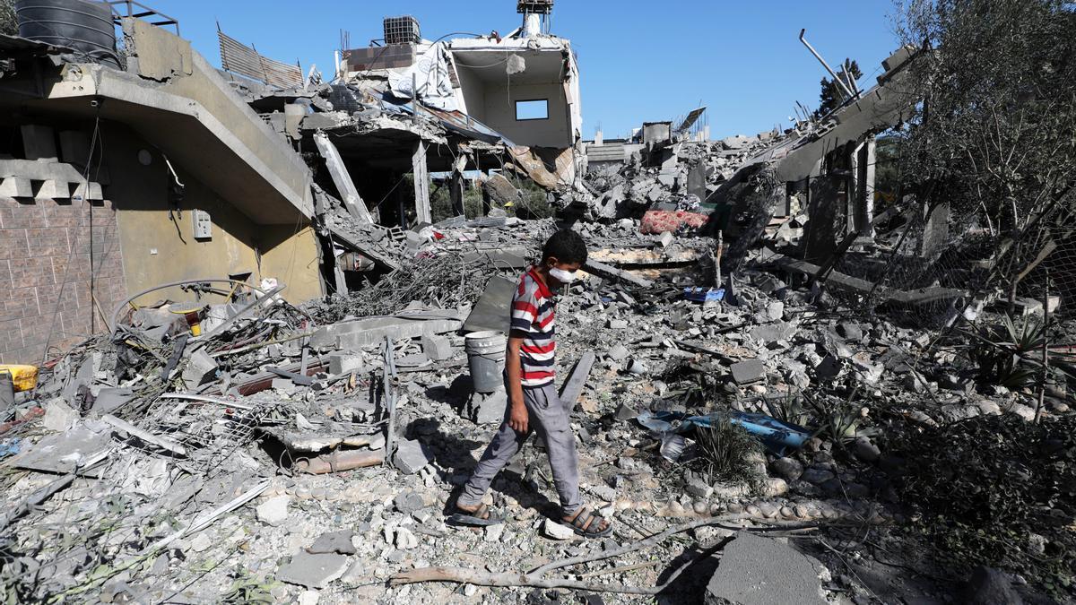 Un niño palestino camina entre escombros en Gaza.