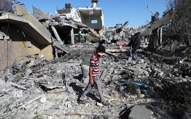 Un niño palestino camina entre escombros en Gaza.