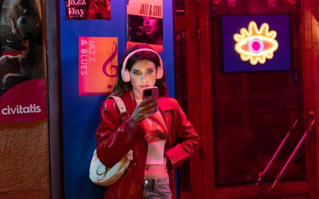 Una joven consultando su móvil.