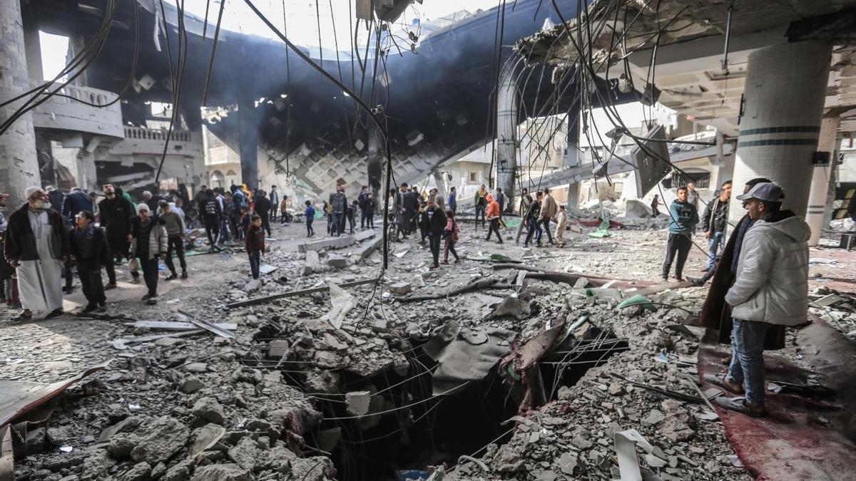 Un grupo de palestinos inspecciona los restos de una mezquita destruida en un bombardeo en Rafah.