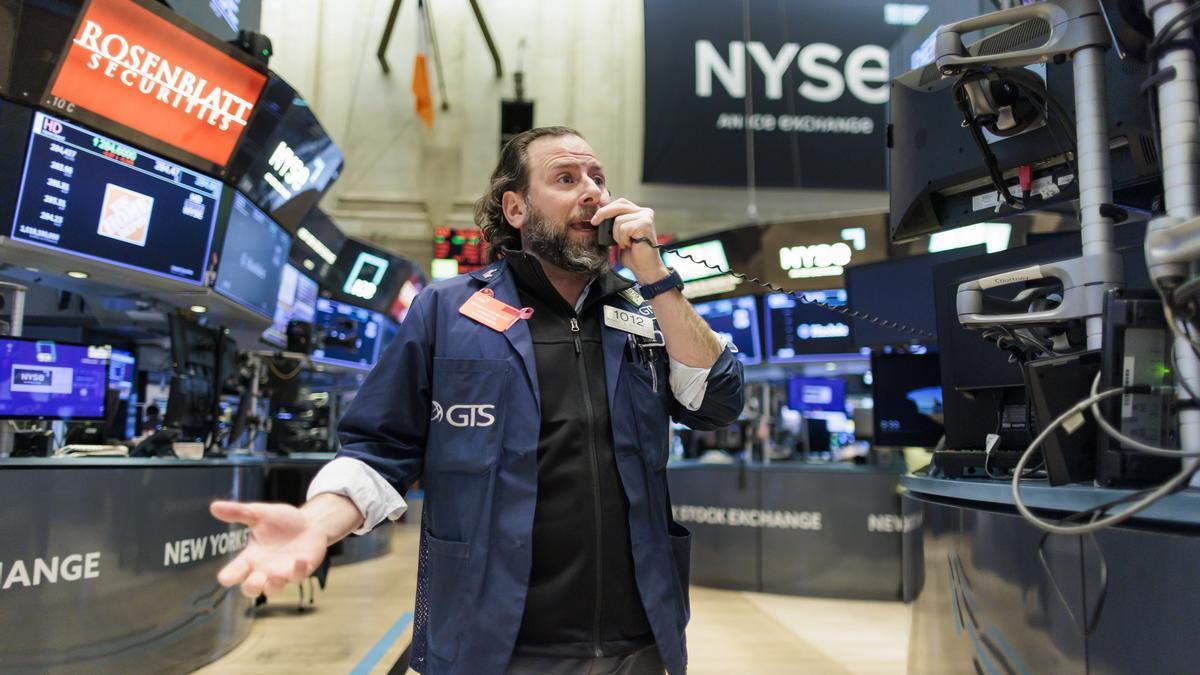 Un operador de bolsa habla por teléfono durante la sesión del pasado miércoles en el mercado de Wall Street, después de conocer el hundimiento de las acciones de Credit Suisse.
