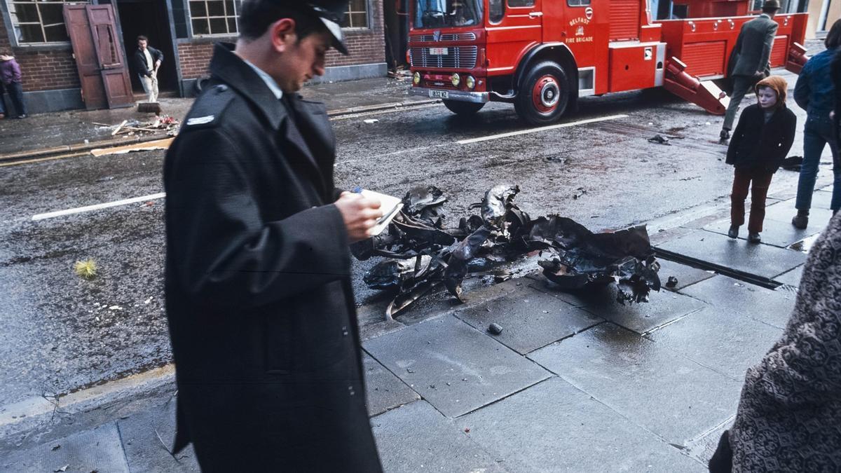 Un policía y un niño cerca de los restos de un coche bomba en Belfast, en una imagen de archivo.