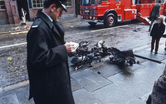 Un policía y un niño cerca de los restos de un coche bomba en Belfast, en una imagen de archivo.