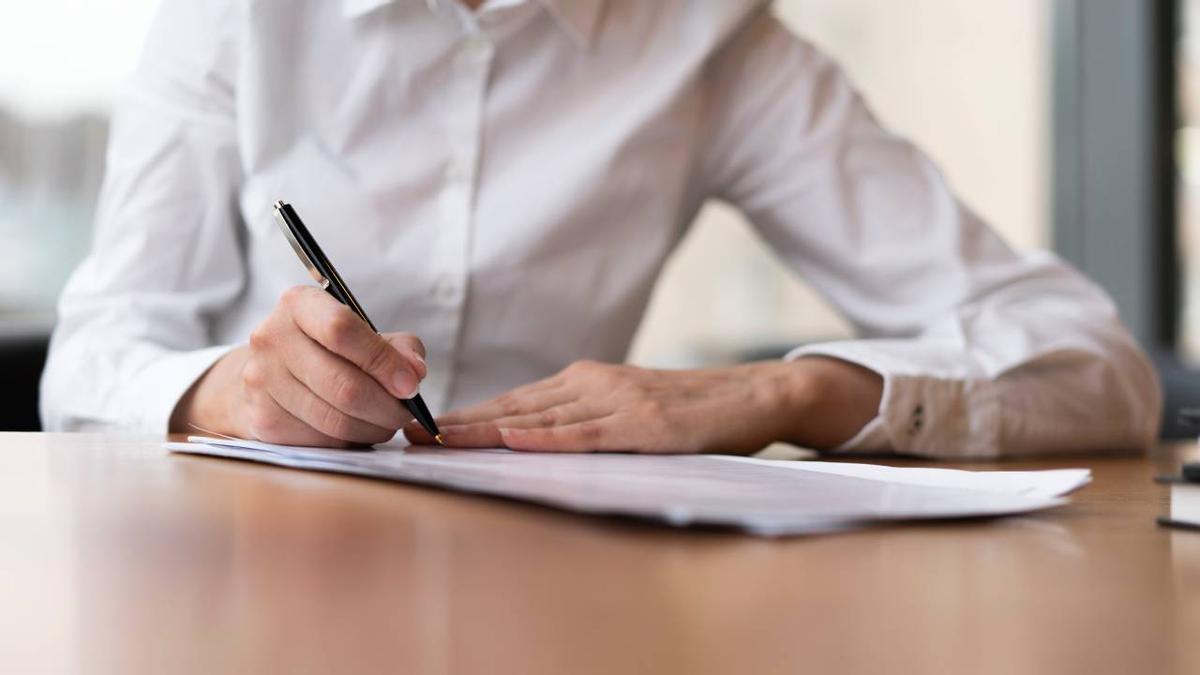 Un profesional firma un contrato laboral