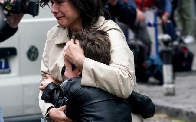 Una mujer consuela a un menor tras el ataque. Una mujer consuela a un menor tras el ataque.