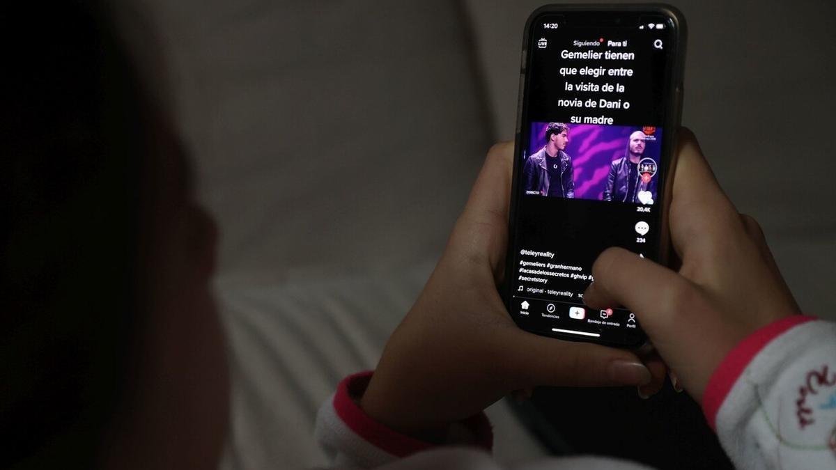 Una menor consume contenido de TikTok en su teléfono móvil.
