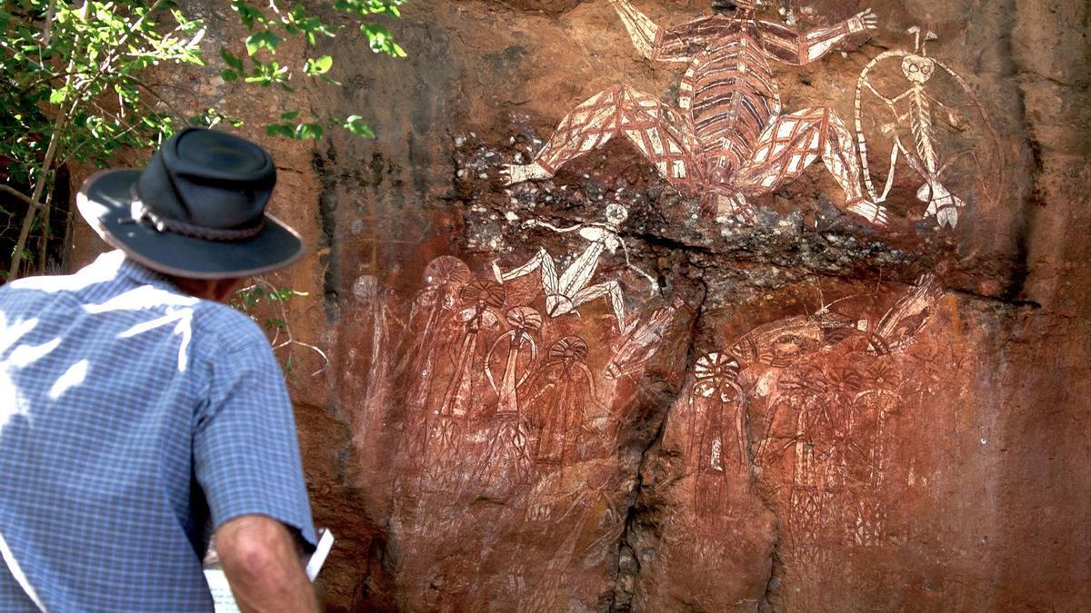 Un turista observa las pinturas rupestres aborígenes en el Parque Nacional Kakadu de Australia