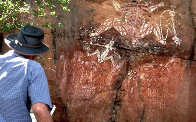 Un turista observa las pinturas rupestres aborígenes en el Parque Nacional Kakadu de Australia