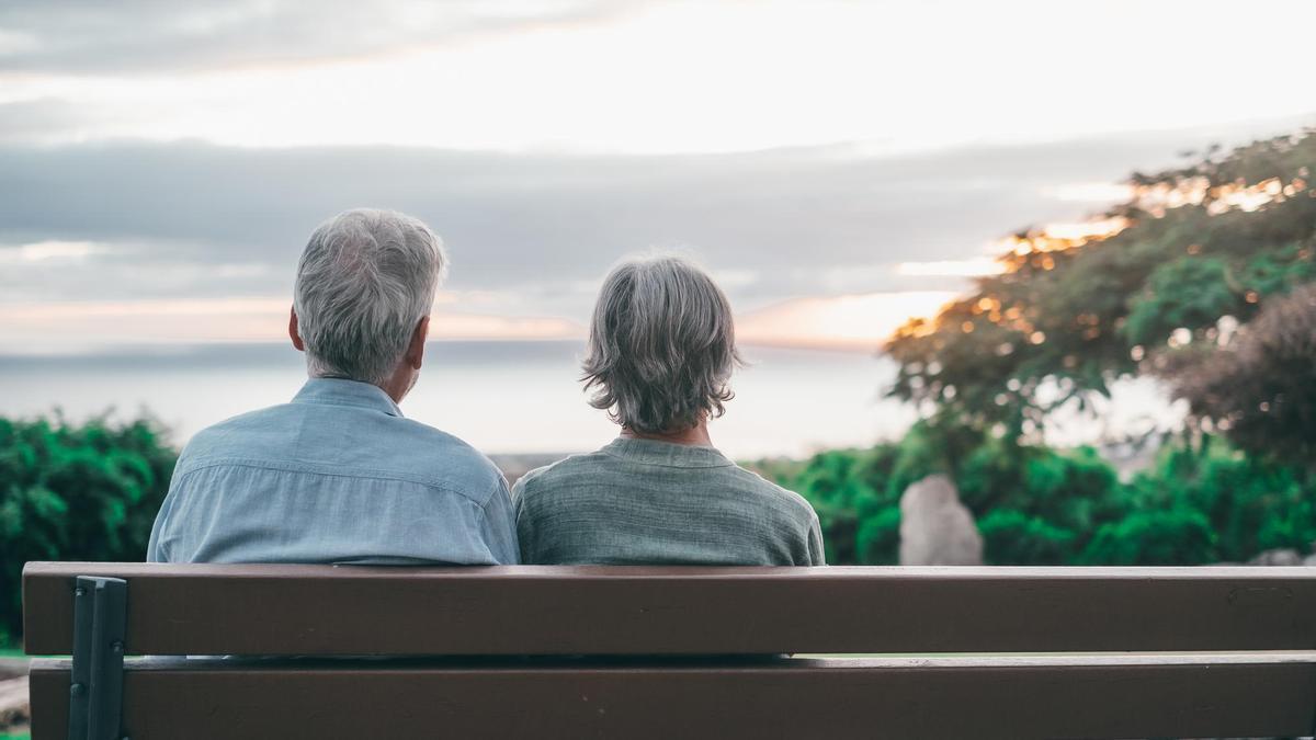 Un hombre y una mujer descansan en un banco mientras disfrutan de las vistas.