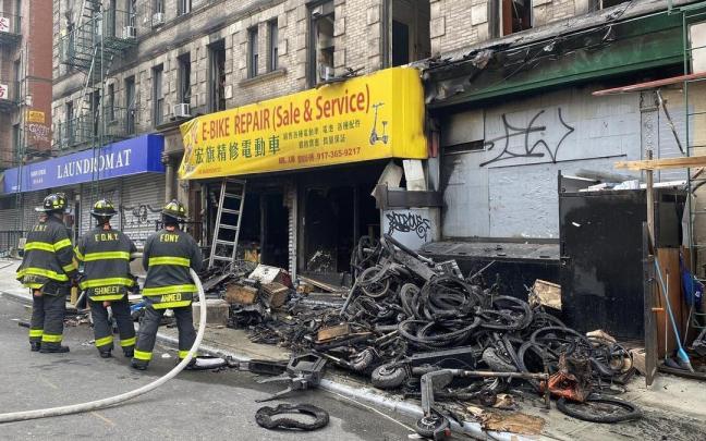 Los bomberos de Nueva York frente a la tienda incendiada en el barrio de Chinatown.