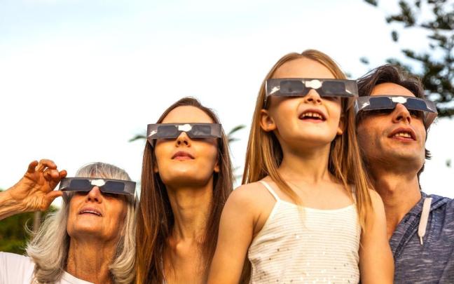Gente observando un eclipse.
