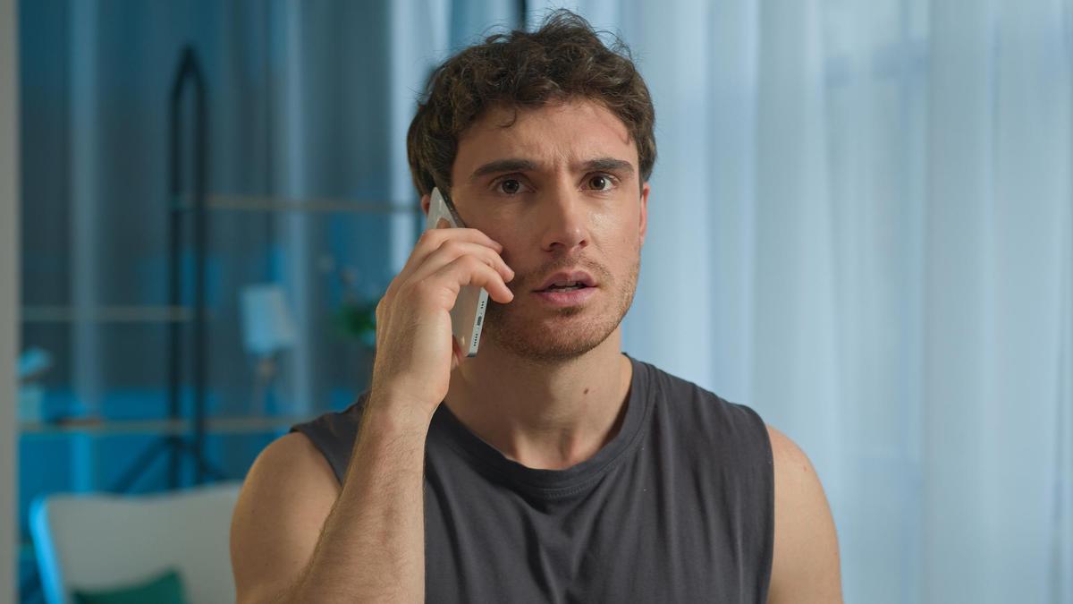 Un hombre responde una llamada en su teléfono móvil.