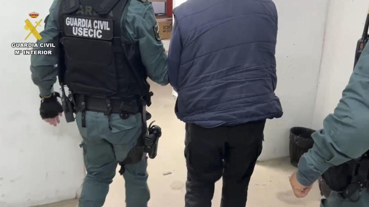 Un agente de la Guardia Civil traslada al detenido por la muerte de Vicente.