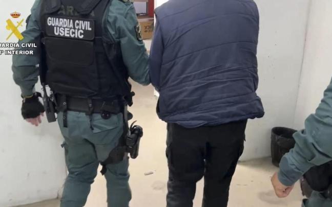 Un agente de la Guardia Civil traslada al detenido por la muerte de Vicente.